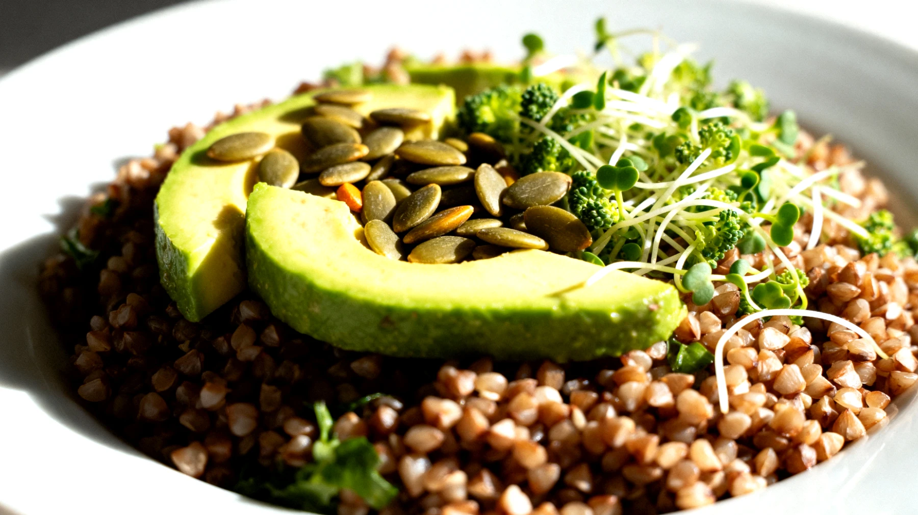 Insalata di grano saraceno con avocado, germogli di broccoli e semi di zucca"