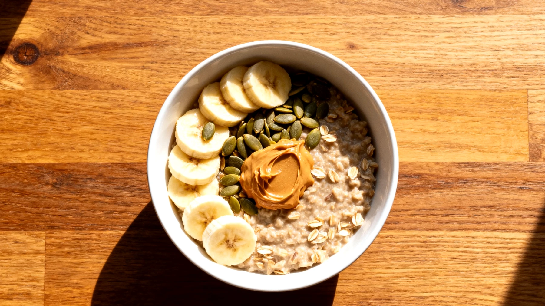 Porridge di avena con semi di zucca, burro di mandorle e banana"